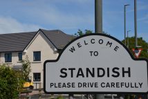 Picture of the standish parish line sign with development in the background