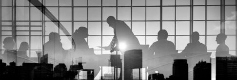 Black and white silhouette of Board Members against a reflected city skyline