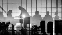 Black and white silhouette of Board Members against a reflected city skyline