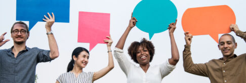 Diverse group of people holding up speech bubbles