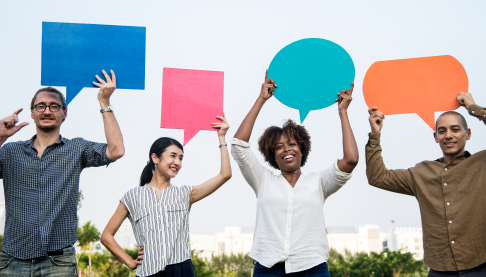 Diverse group holding up speech bubbles