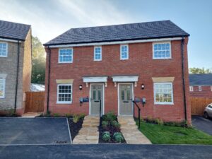 Redbrick semi detached new homes, with white window panes and brown doors